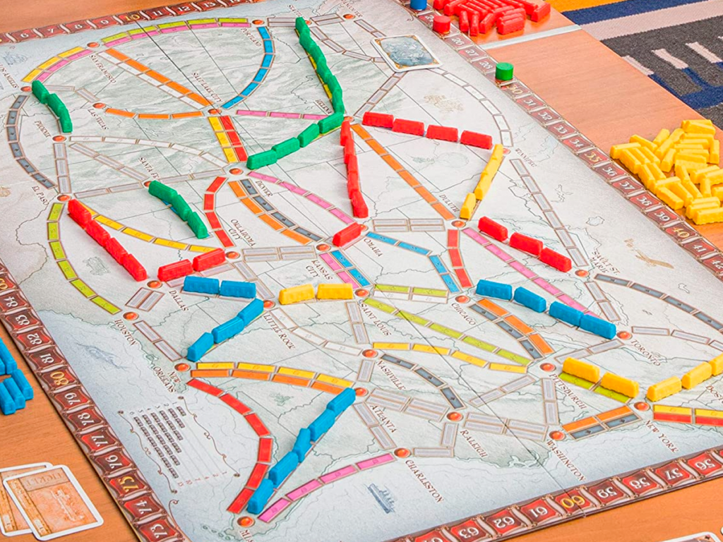 The Ticket to Ride board game map filled with plastic trains during gameplay.