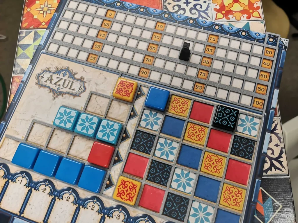 Colorful resin tiles arranged on the player boards of the Azul board game.